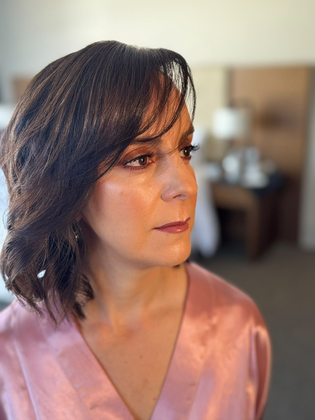 Maquillaje social con piel luminosa y mirada definida, de perfil.